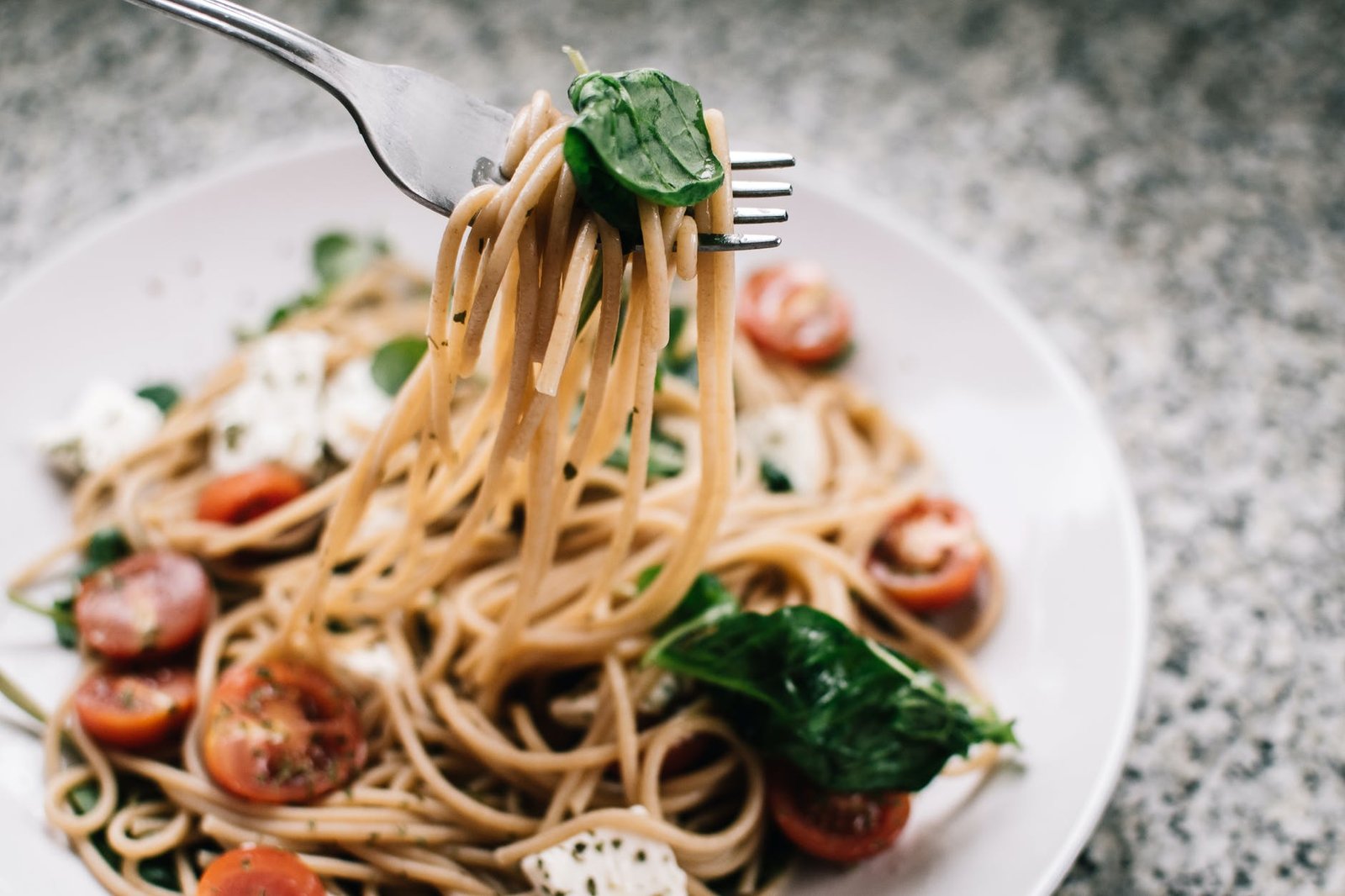 selective focus photography of pasta with tomato and basil vegan food in Barbados