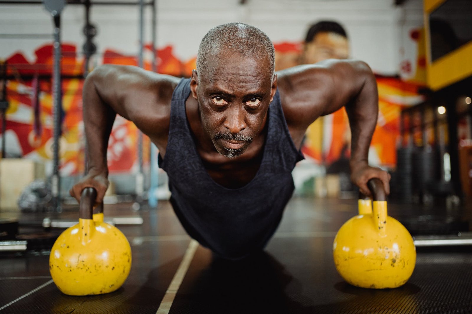 photo of man doing push ups using yellow kettlebell gyms in Barbados