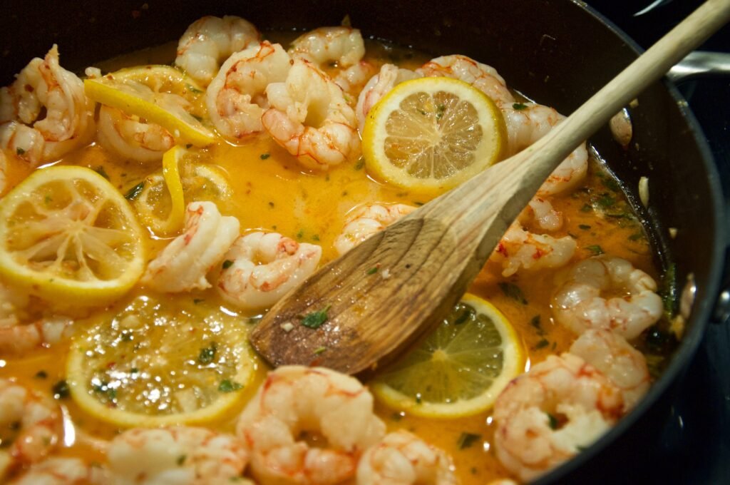 shrimp and lemon with sauce stir fried in a pan