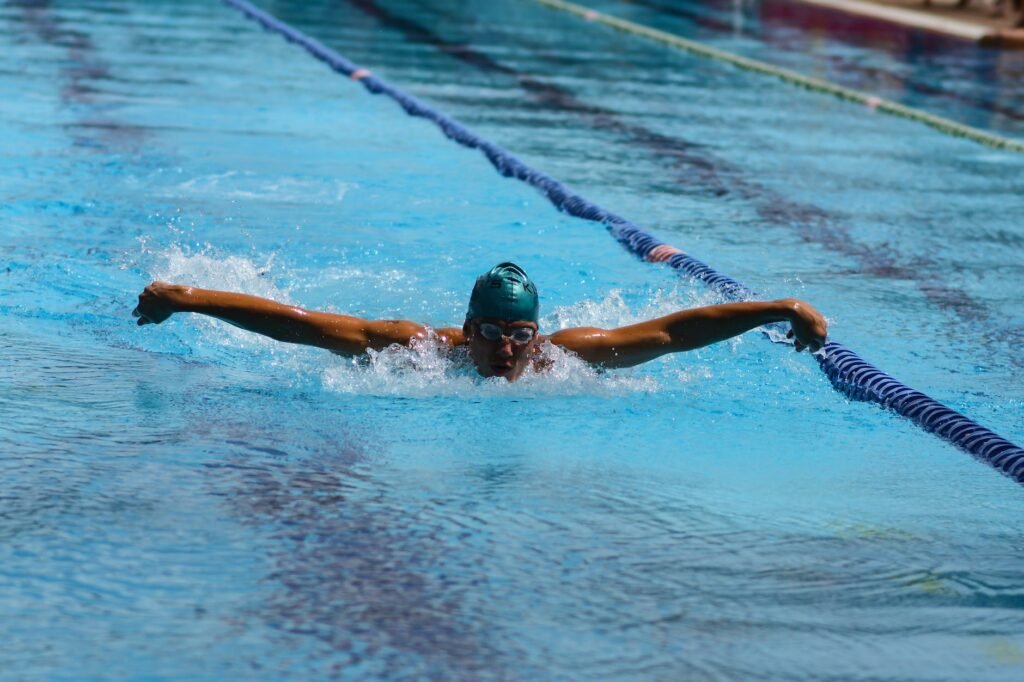 man wearing goggles swimming on pool